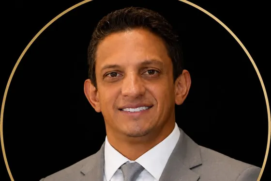Retrato do Dr. Alberson Mendonça, de terno cinza e gravata, sobre fundo preto.